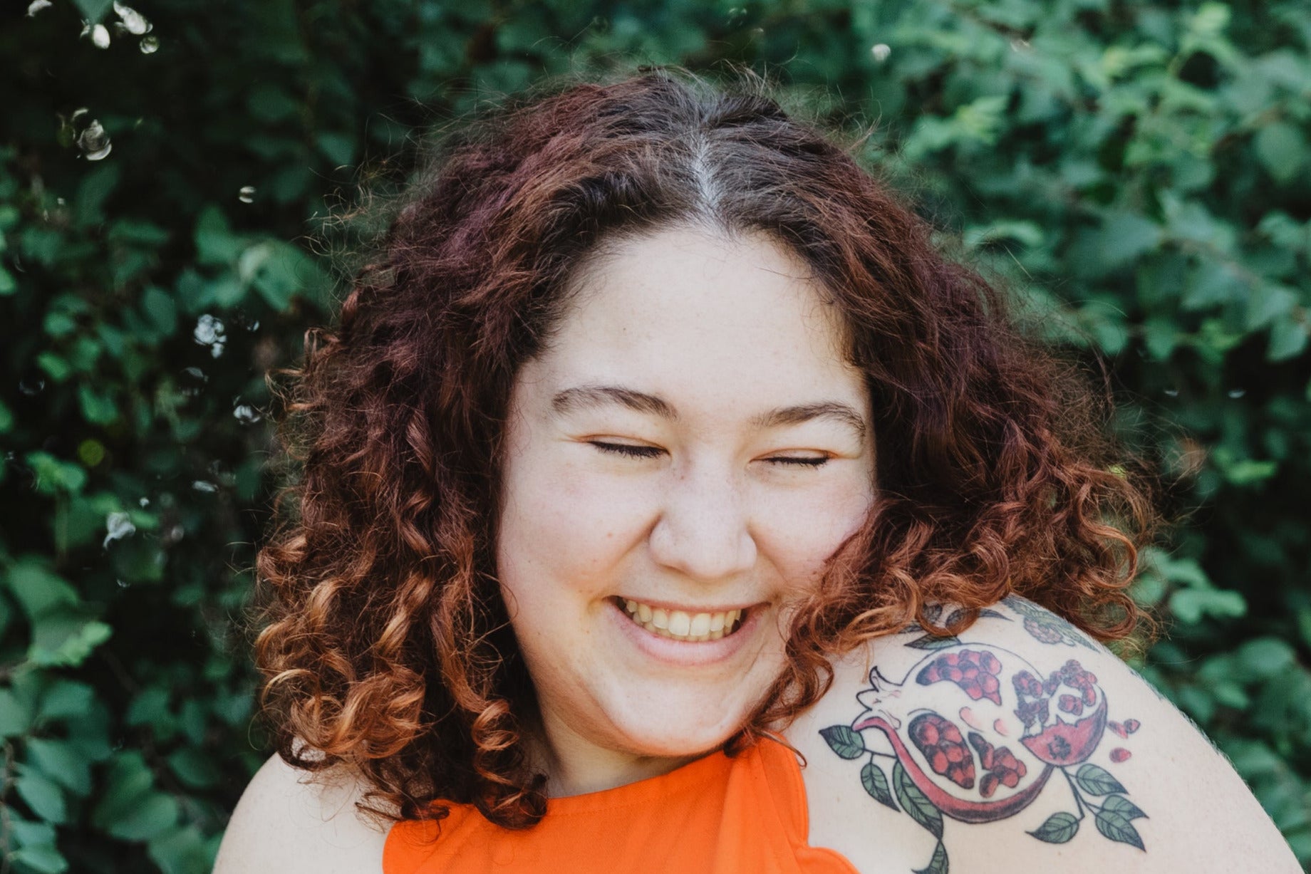 files/young-woman-in-orange-shirt-with-pomegranate-tattoo.jpg